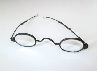 A pair of adjustable, wire-rimmed spectacles with oval glass and frames.