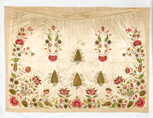 A silk apron embroidered with red flowers and spade-shaped leaves.