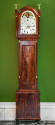 A mahogany tall case clock with an arched bonnet with two brass eagle finials on box plinths ab…