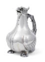 A silver claret jug in the form of a bird of prey with a feathered handle and emerald- colored …