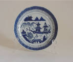 A porcelain saucer from a set of dinnerware featuring blue and white Chinese landscapes.