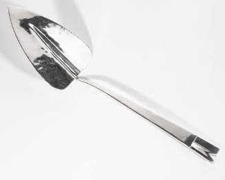 A mid-century silver pie server with a heart-shaped blade and the handle end cut as the letter …