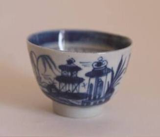 A porcelain teacup with no handle from a set of dinnerware featuring blue and white Chinese lan…