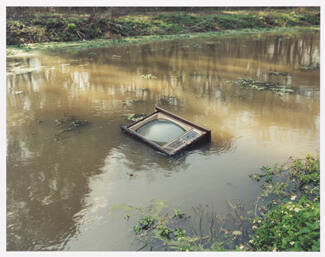 A photograph in mainly brown and green tones depicting a cabinet-style television floating scre…