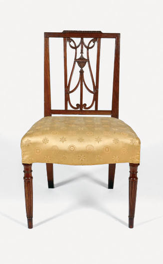 A frontal view of a mahogany side chair with a gold upholstered seat and lyre-style back.