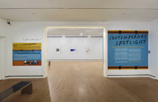 An installation shot of the title wall and explanatory lithography text panel on either side of…