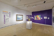 An installation shot of the title and introductory text panel on the left and the entrance to t…