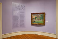 An installation shot of the title wall with an introductory text panel on the left and "The Unp…