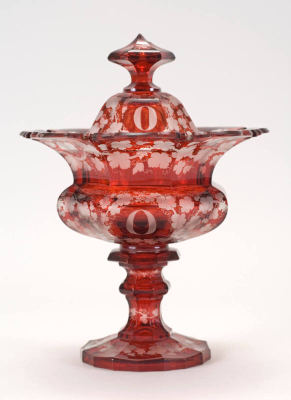 One of six ruby-flashed glass compotes with a scalloped rim, etched grape leaf design, a pedest…