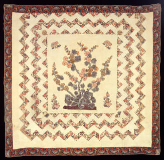 A quilt with a clump of hollyhocks as the central motif, three pieced zigzag borders of floral …