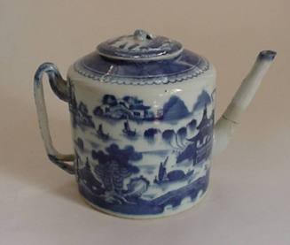A porcelain teapot from a set of dinnerware featuring blue and white Chinese landscapes.