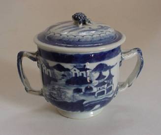 A porcelain sugar bowl from a set of dinnerware featuring blue and white Chinese landscapes.