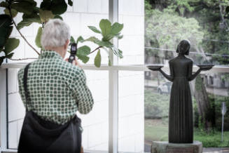 A visitor documents the iconic Bird Girl sculpture by Sylvia Shaw Judson, a visitor favorite.