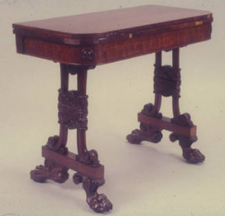 A mahogany card table with a flip top revealing a green felted surface and four carved supports…