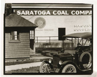 A black and white photograph of a car in front of the Saratoga Coal Company building.