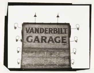 A black and white photograph of a brick façade with the words “Vanderbilt Garage.”