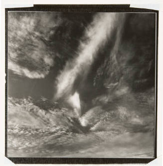 A black and white photograph of thin, wispy clouds in the sky.