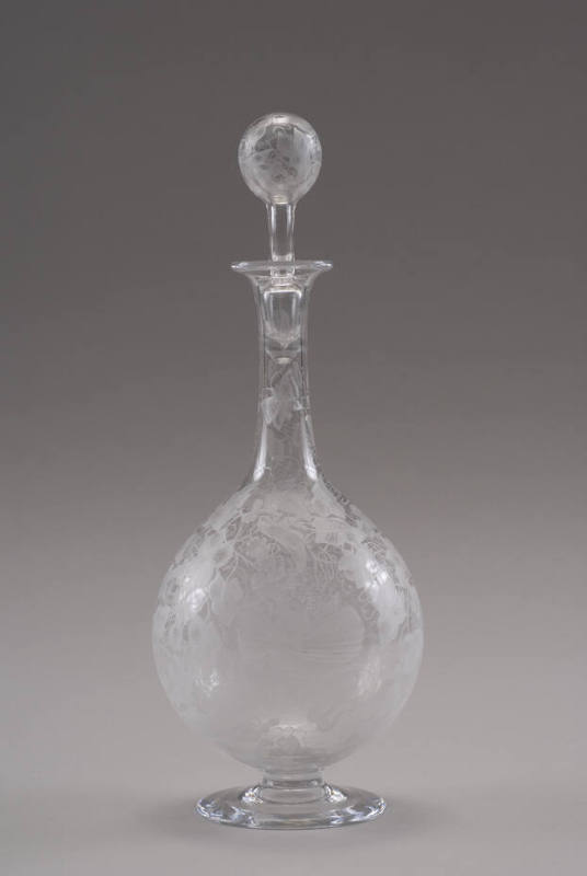 A blown clear glass footed decanter with a stopper, etched with hummingbirds and morning glory …