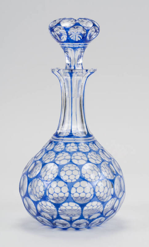 Originally one of a pair, a blue-flashed glass decanter cut to clear with a design of circles.