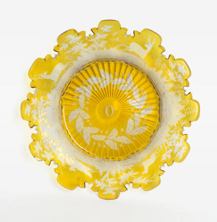 Engraved yellow glass plate with decorative cut trim, flora and fauna scenes, and initial "O" i…