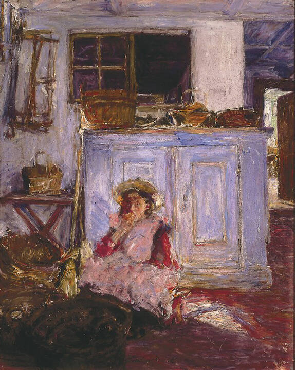 A girl sits on the floor behind a cupboard eating apples. 