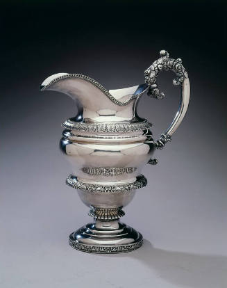 A silver pitcher with an inverted pear-shaped body with flared lips, flared acanthus leaf bandi…