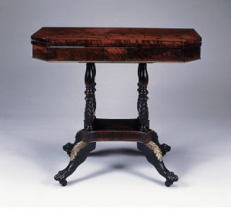 A mahogany card table with a folding, swivel top with canted corners. The frieze with brass tri…