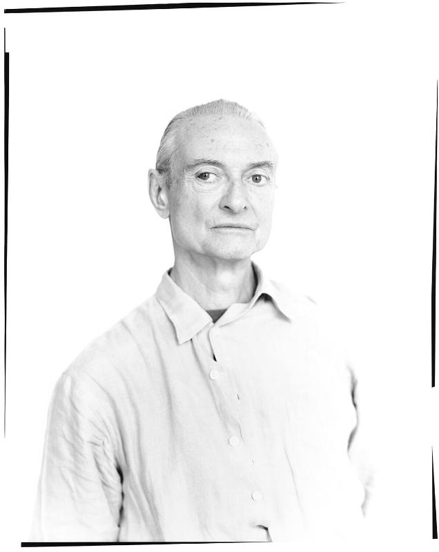 An oversized black and white photograph of a man in a buttoned-down shirt, artist Roy Lichtenst…