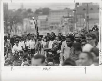A black and white photograph of a crowd of Civil Rights protestors in Selma, Alabama. A young A…