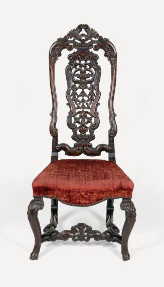 One of two Elizabethan Revival chairs with carved surfaces featuring foliage, C- and S-scrolls,…