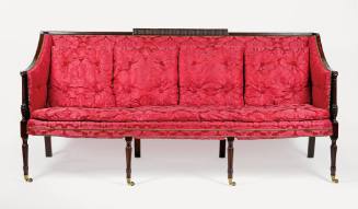 A Sheraton-style sofa upholstered in modern red silk.