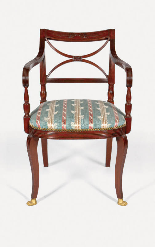 A mahogany armchair from a set of seven, each with a scroll back crest panel with carved thunde…