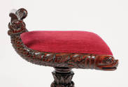 A detail of the carved mahogany dolphin seat rail. 