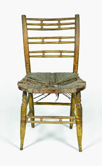 A painted wooden chair with two pairs and one triplet of spindles separated by balls and a rush…
