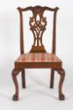 An American mahogany Chippendale-style chair with a curlicue back splat, heavily-carved crest s…