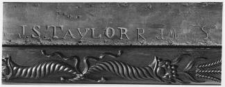 A detail of the maker's signature, "J. S. Taylor," carved into the central panel underneath ent…