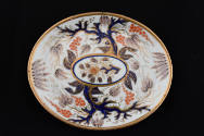 The stand in the same pattern of a tree and its base leaves in underglaze blue, outlined in gol…