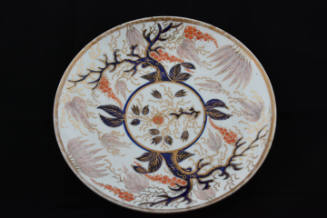 A saucer from a twenty-one-piece tea service characterized by a tree and its base leaves in und…