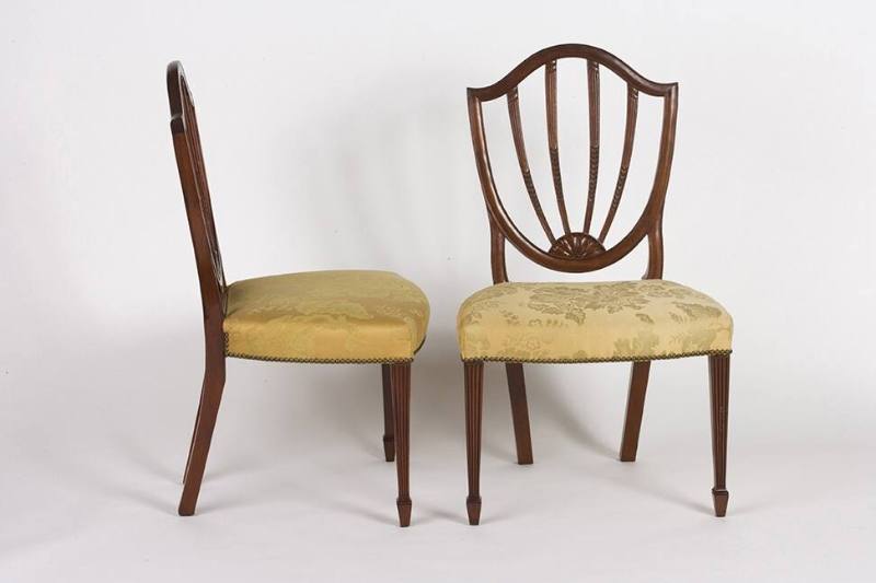 A Hepplewhite-style shield-back chair with a gold floral upholstered seat.