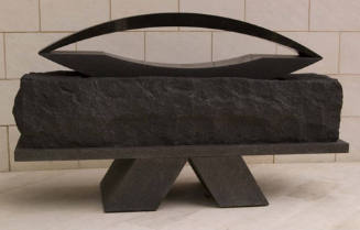 A black stone sculpture comprised of three textural surfaces in the form of a rectangular block…