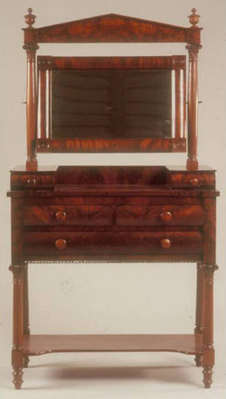 A dressing table with a swivel mirror above a table with five drawers all with wooden knobs.