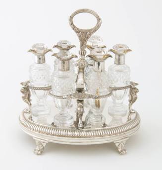 A silver thirteen-piece cruet set stand with monopod lion supports and an engraved crest in the…